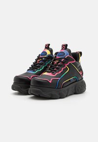 Black sneakers with a chunky sole, featuring colorful accents in pink, yellow, and green. Textured synthetic material and logo detail.