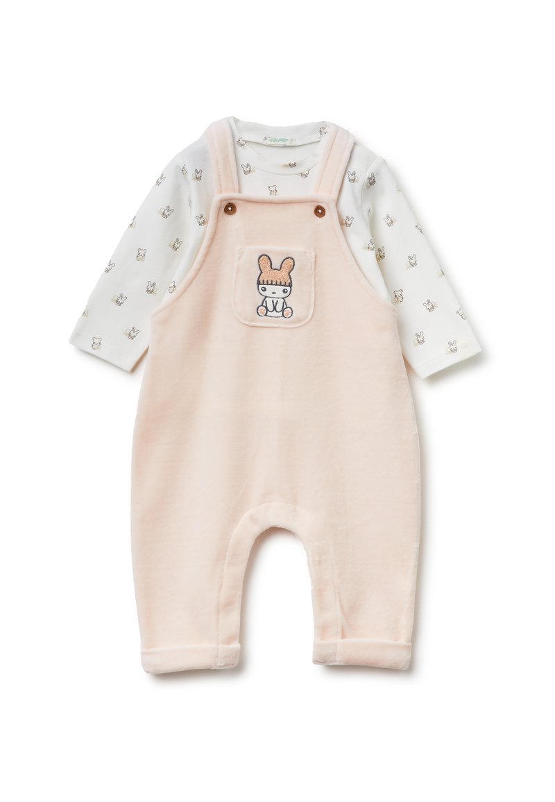 Różowe polarowe kombinezony z detalu kieszeni w formie królika, w zestawie z długim rękawem białej koszulki z małymi wzorami zwierząt. Miękka tekstura.