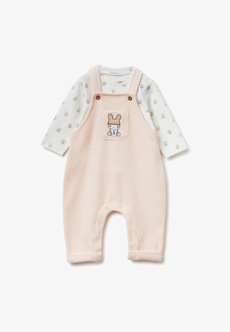 Różowe polarowe kombinezony z detalu kieszeni w formie królika, w zestawie z długim rękawem białej koszulki z małymi wzorami zwierząt. Miękka tekstura.