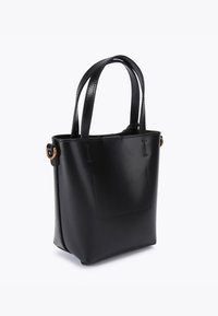 Sac fourre-tout en cuir noir avec une texture lisse, une forme structurée, de courtes poignées doubles et un subtil détail de patch carré à l'avant.