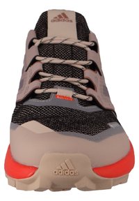 Adidas running shoe with a black and gray mesh upper, beige and orange accents, textured sole, and a lace-up front design.