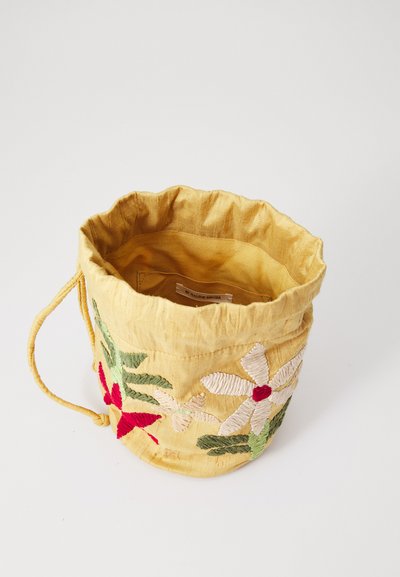 Gul stofbøttepose med en broderet blomsterdesign i rød og grøn, med en samlet top og snøre lukning.