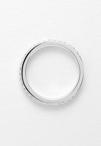 Silberner Ring mit einem glatten Band, das eine klare Kristallverzierung entlang der äußeren Kante aufweist. Runde Form, polierte Oberfläche.