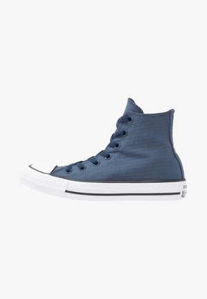 High-Top-Sneaker aus marineblauem Stoff mit strukturierter Oberfläche, weißer Gummikappe an der Spitze und schwarzer Sohle mit Streifen. Verfügt über blaue Ösen und Schnürsenkel.