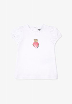 Maglietta bianca per neonati con maniche a sbuffo e un piccolo orsetto che tiene un cuore rosa al centro davanti.