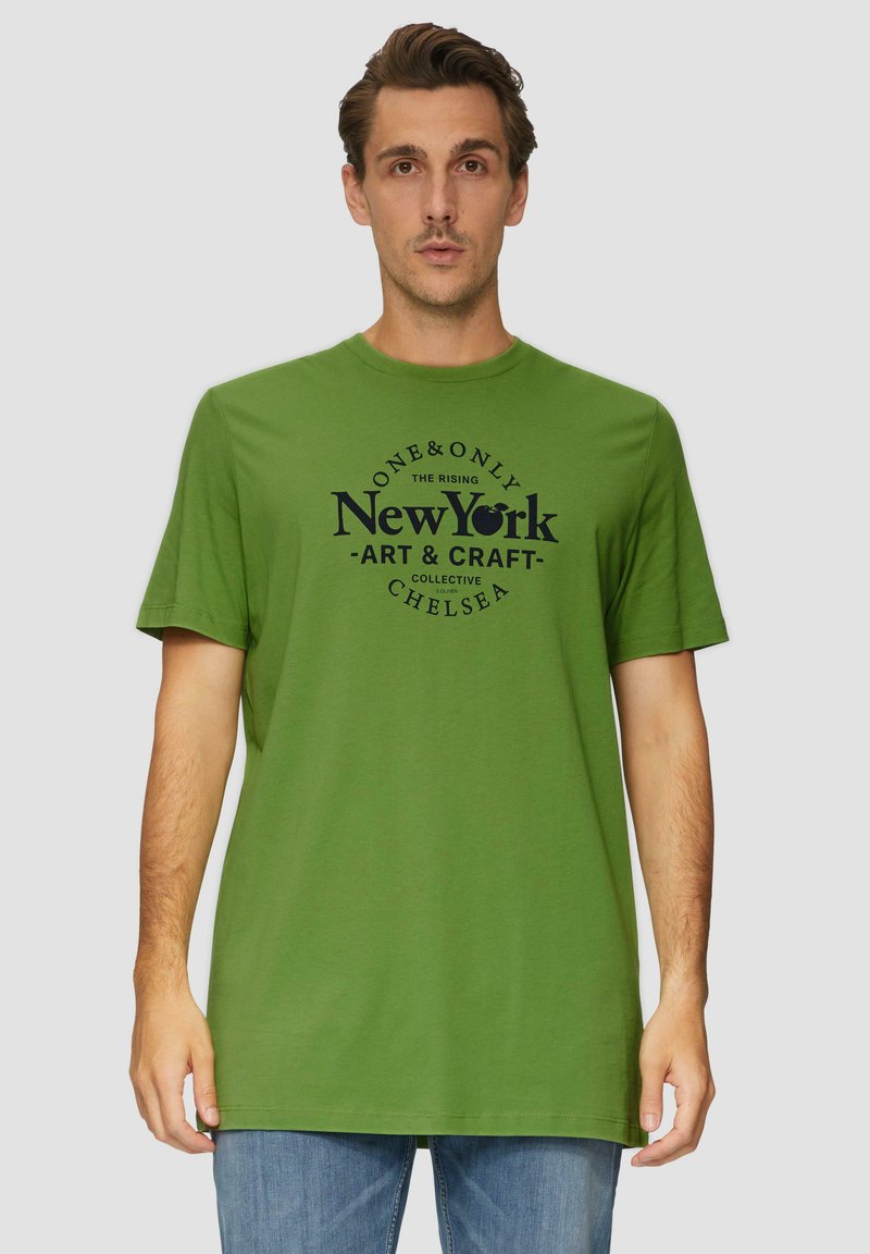 Zelené bavlněné tričko s kulatým výstřihem a krátkými rukávy, na kterém je vytištěná grafika s nápisem "New York - Art & Craft" v tmavě modré barvě.