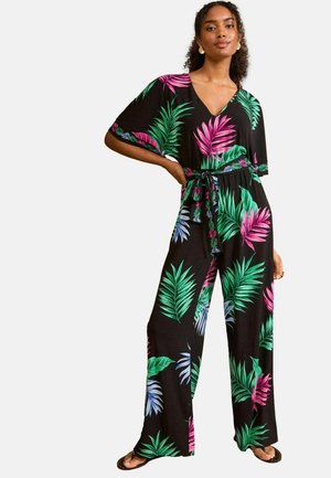 Schwarzer Jumpsuit mit V-Ausschnitt, kurzen Ärmeln und gebundenem Taillenbereich. Er hat ein tropisches Blattmuster in Grün, Rosa und Blau.