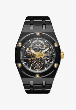 Skeletalur med svart metallarmband, oktagonal klokkehus, gjennomsiktig urskive som avslører gullaksenter, gir og lilla detaljer.