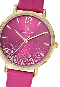 Montre rose ronde avec un boîtier en ton or, présentant un design dégradé scintillant avec des cristaux, des index horaires dorés et un bracelet en cuir rose.