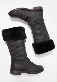 Bottes en cuir noires montantes jusqu'au genou, avec un doux bord en fourrure noire, une semelle texturée et un logo discrètement embouti sur le côté.