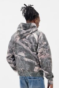 Camo hoodie i grå og grønne nuancer med en tekstureret stof, der har en snor i huften og oversized pasform, vist fra ryggen.