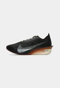 Schwarzer Laufschuh mit strukturiertem Obermaterial, reflektierendem Swoosh-Logo, hellen Schnürsenkeln und einer gepolsterten Sohle mit einem Farbverlaufseffekt.