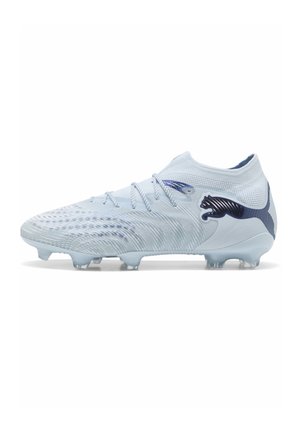 Scarpa da calcio azzurro chiaro con tomaia strutturata, lacci e logo Puma blu scuro sul lato, progettata per il gioco su terreni compatti.