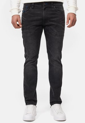 Sorte slim-fit jeans lavet af denim med subtil tekstur. Har blå syninger, fem lommer og en standard talje. 