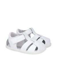 Sandalias de cuero blanco con lados abiertos, que cuentan con una correa de Velcro, acentos plateados en contraste y una suela de goma texturizada.