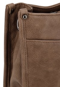 Brun lædertaske med glat tekstur, der har metalhardware og en sidelomme. Designet inkluderer synlige syninger og forstærkede kanter.