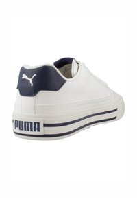 Zapatillas blancas con un talón texturizado en marino, que presentan un logo en la parte trasera y rayas horizontales en navy a lo largo de la suela para añadir detalle.