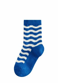 Blå bomullssocka med vita vågiga ränder. Ribbad mudd och jämn textur. Ankellång design med förstärkt tå och häl.