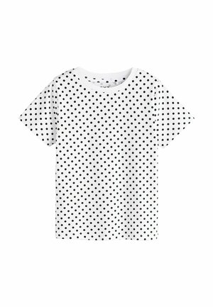 White short-sleeve t-shirt with black polka dots evenly covering the fabric and a round neckline.