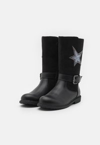 Zwarte laarzen van een mix van leer en suede, hoogte tot halverwege het kuit, met een metallic zilveren steraccent en gespsdetails. Platte zool.