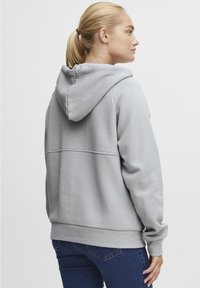 Hallide hallis kapuutsiga sviiter, mis on valmistatud fliismaterjalist, käes on känguru tasku, soonikkoes mansetid ja mugav lõige. Minimalistlik disain ilma mustriteta.