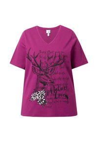 T-shirt à manches courtes fuchsia vif avec col en V, présentant un graphisme de cerf noir et des accents floraux blancs avec du texte. Matériel en coton.
