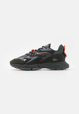 Czarny i ciemnozielony sportowy sneaker z teksturowaną podeszwą, pomarańczowymi pętelkami do ściągania i małym logo zwierzęcym po boku, pokazany z profilu.