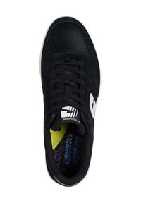 Zapatilla negra que presenta una combinación de cuero liso y ante, acento de logotipo blanco, puntera redonda y una plantilla texturizada con detalles en amarillo.