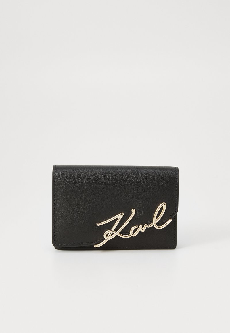 Black leather wallet featuring a signature-style gold logo on the front, with a smooth texture and a folded design.