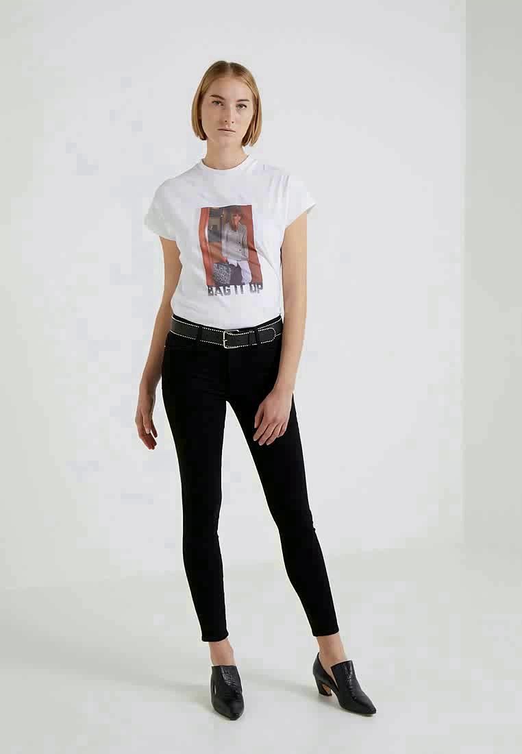 White cotton t-shirt with front graphic and text "BAG IT UP," paired with black slim-fit jeans and black pointed-toe shoes.