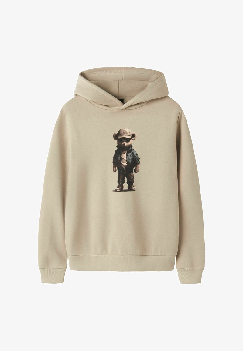 Sweat à capuche beige avec un graphique d'un ours portant une casquette, une veste, un pantalon et des baskets, positionné au centre à l'avant.