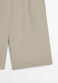 Beige shorts lavet af letvægtigt stof, med lige snit, sidelommer og ren syning langs kanten.