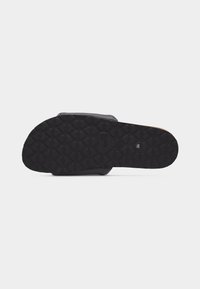 Μαύρη σόλα σανδαλιού με σχέδιο πέλματος σε σχήμα καρδιάς και ανάγλυφο το "LOVE MOSCHINO" στο κέντρο, μέγεθος 38 εμφανίζεται.