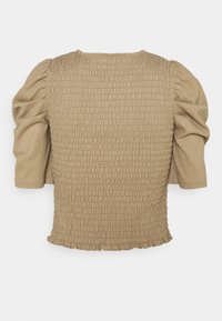 Beige top met korte mouwen, geplooid en met opgeblazen mouwen en een licht gerimpelde zoom.