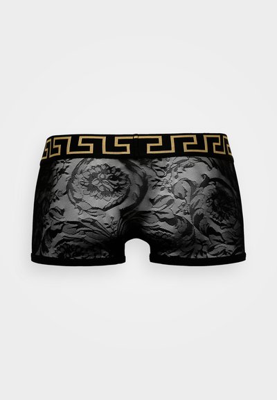 Boxer shorts en dentelle noire avec un motif floral, une ceinture élastique noire ornée d'un design grec en or. Texture lisse.
