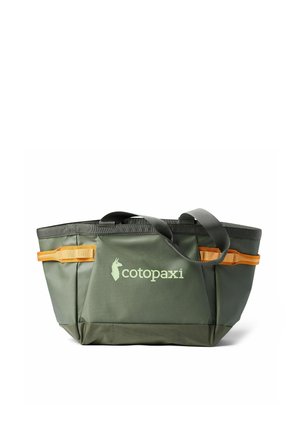 Green and dark green tote bag with black handles and orange side loops, featuring the Cotopaxi logo in light green on the front pocket.