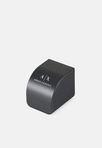 Imballaggio rettangolare nero con angoli arrotondati, con il logo bianco "A/X ARMANI EXCHANGE" sulla parte anteriore. Superficie liscia e opaca.