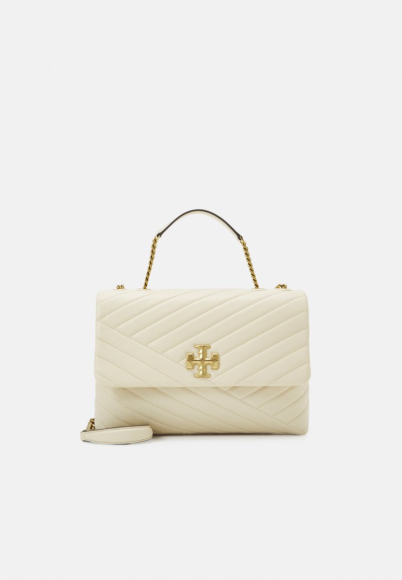 Quiltet creme taske med et guldlogo-accent, der har et greb på toppen og en aftagelig skulderrem, foret med en glat tekstur.