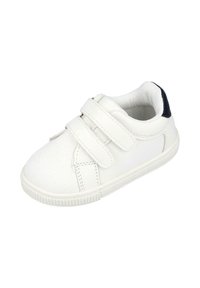 Zapatilla de lona blanca con dos correas de velcro, punta redonda, suela de goma y un acento en el talón de color azul marino. Diseño simple con una superficie texturizada.