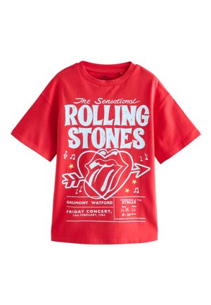 Camiseta roja de manga corta con texto blanco de Rolling Stones, el icónico logo de la lengua dentro de un corazón con flecha, notas musicales y detalles del concierto.