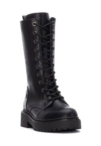 Bota de cuero negro hasta la rodilla con punta redonda, cordones prominentes, ojales de metal y una suela gruesa y robusta con surcos profundos.