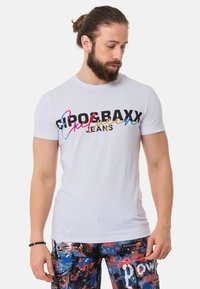 Weißes Baumwoll-T-Shirt mit "Gropax" in fettem Schwarz und bunten kursive Akzenten. Enganliegendes Design, Rundhalsausschnitt, kurze Ärmel, glatte Textur.