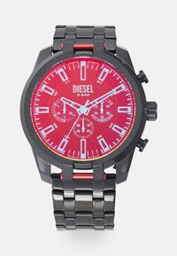 Schwarze Edelstahl-Uhr mit rotem Zifferblatt, auffälligen weißen Markierungen und Chronographenfunktionen. Akzente sind eine rote Krone und Glieder.