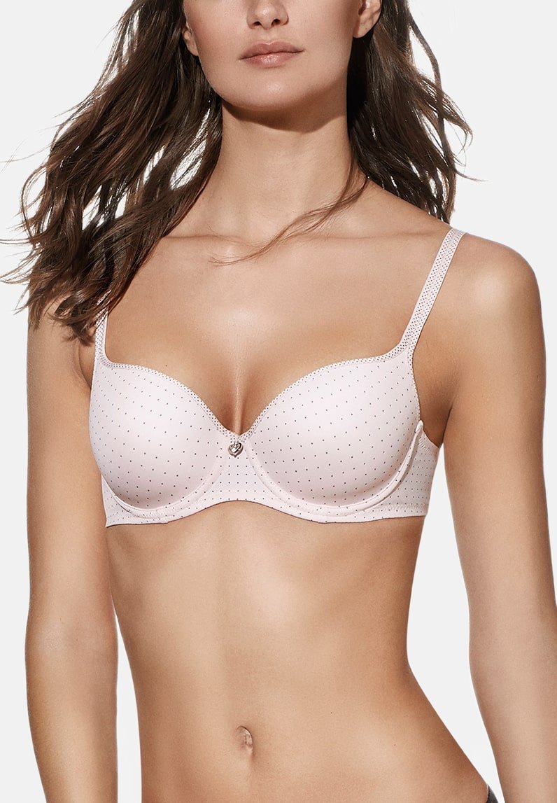 Sujetador de color rosa claro con un patrón de lunares, copas acolchadas, tirantes ajustables y un pequeño charm decorativo en el centro. Textura de tela suave.