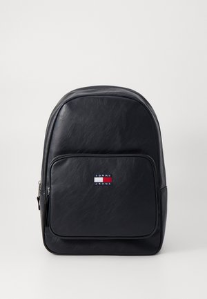 Juodas dirbtinės odos kuprinės modelis su apvaliu viršumi, priekinė zip kišenė ir siuvinėtas "Tommy Jeans" logotipas raudona, balta ir mėlyna spalvomis.