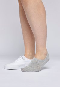 Grå bomuldsankelsok med subtil tekstur, parret med en hvid canvas sneakers på en lys baggrund.