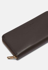 Portafoglio in pelle marrone con finitura testurizzata, dotato di una cerniera dorata e logo impresso. Design slim con forma rettangolare.