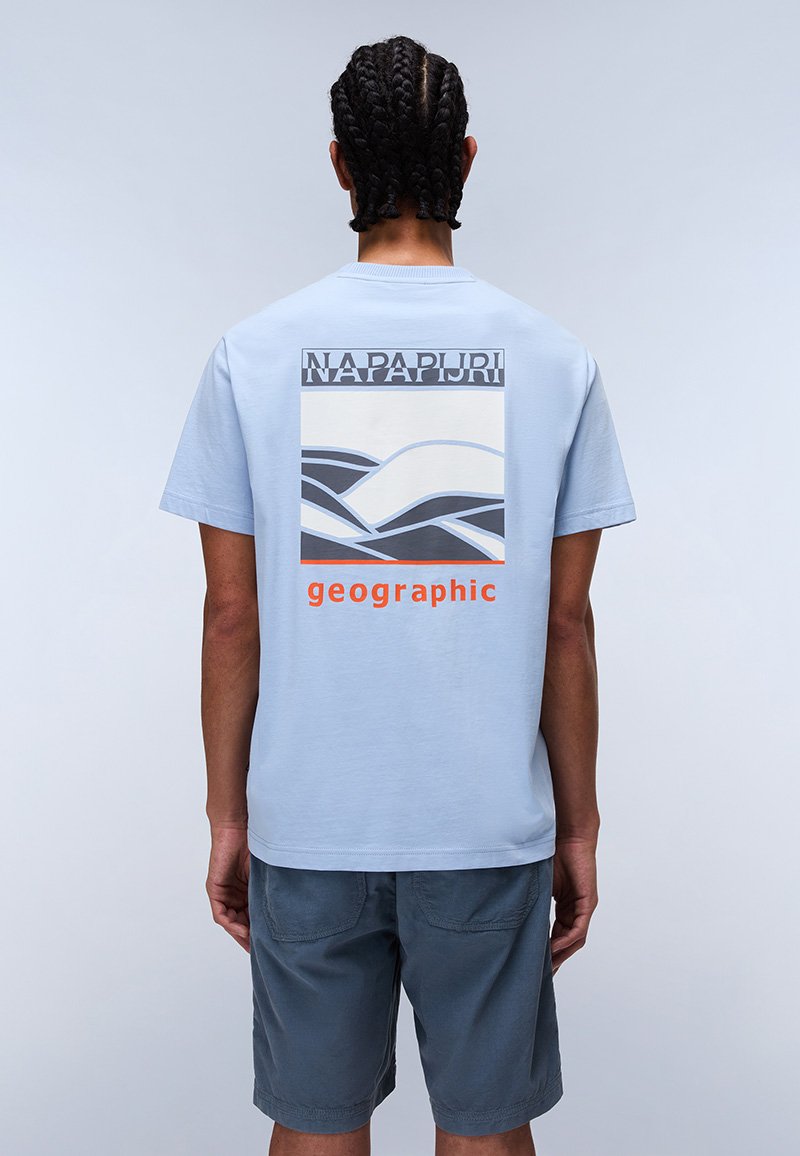 Light blue cotton t-shirt with a graphic design featuring waves and the text "NAPAPIJRI geographic" in orange. Short sleeves and relaxed fit.