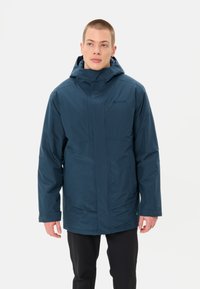Giacca impermeabile navy con colletto alto, cappuccio regolabile e tasche con zip; tessuto texture con finitura liscia; design non isolato.