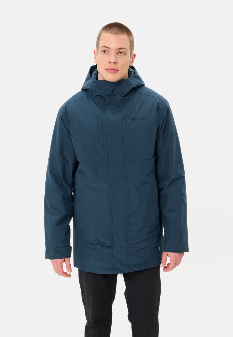 Giacca impermeabile navy con colletto alto, cappuccio regolabile e tasche con zip; tessuto texture con finitura liscia; design non isolato.
